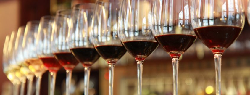 Some long wine glasses filled with wines